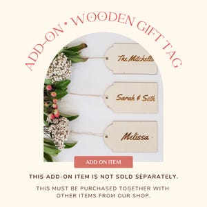 May include: Three wooden gift tags with twine, each with a different name engraved in gold lettering: "The Mitchells", "Sarah & Seth", and "Melissa". The tags are displayed against a white background with white flowers and red berries.