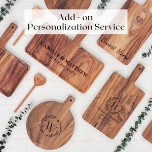 May include: A collection of wooden serving boards and small heart-shaped spoons with laser-engraved text and designs. The boards feature various names and dates, including Camille & Matthew, Alyssa & Edmond, and the text Add-on Personalization Service.