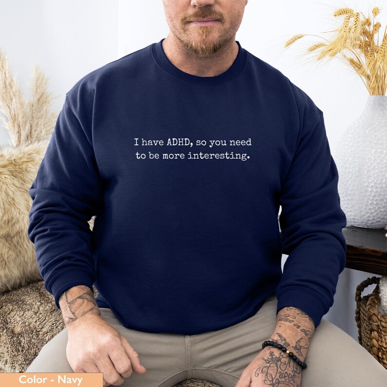 May include: Navy blue sweatshirt with the text "I have ADHD, so you need to be more interesting." printed in white. The sweatshirt is a crew neck style.