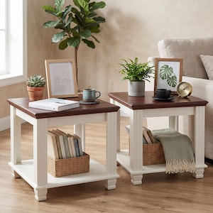 May include: Two square end tables featuring a dark brown wooden top and a white base with four legs and a lower shelf. Each table holds a woven basket, a potted plant, a framed picture, and a beverage container, with one table holding a book.