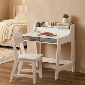 May include: A white wooden desk with two gray fabric drawers and a matching white chair. The desk features a top shelf with compartments holding pens, a notebook, and books. A small potted succulent sits on the stack of books on the desk surface.