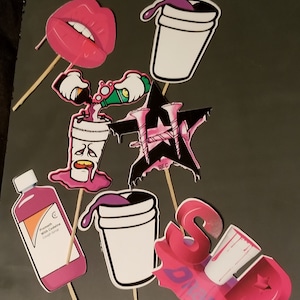 Puede incluir: Un conjunto de seis accesorios de fiesta coloridos que incluyen una boca rosa, una taza púrpura y blanca, una taza rosa y blanca, una taza rosa y blanca con una cara de dibujos animados, una taza rosa y blanca con una mano de dibujos animados vertiendo un líquido verde y una taza rosa y blanca con las palabras "Sip Drink" en rosa.