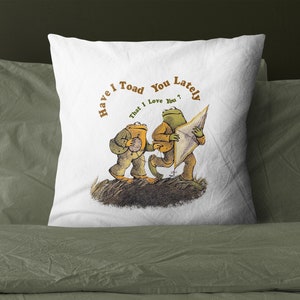 May include: White pillow with a brown and green illustration of two frogs. The text on the pillow reads "Have I Toad You Lately That I Love You?"