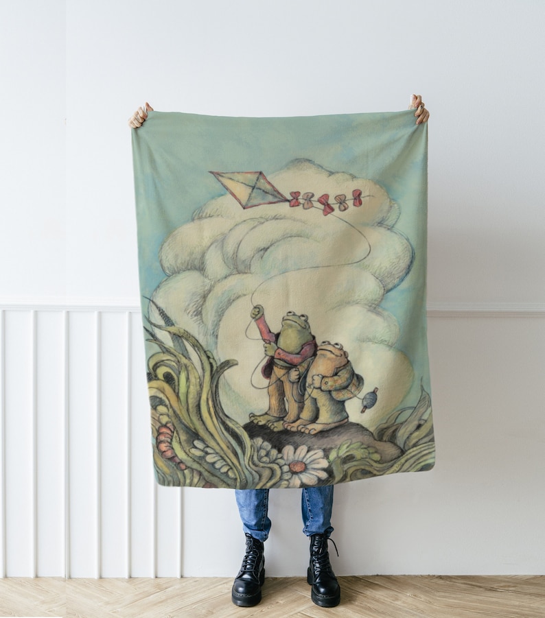 May include: Two frogs holding a kite string, flying a red and white kite in a blue sky with white clouds. The frogs are standing on a rock with green grass and flowers. The background is a light blue sky with white clouds.
