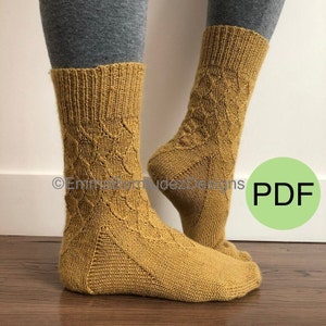Op de afbeelding: Een paar mosterdgele gebreide sokken met een ruitpatroon. De sokken worden getoond op de voeten van een persoon. De afbeelding bevat ook de tekst "PDF".