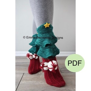 May include: Knitted Christmas tree leg warmers with red and white gift ornaments. The leg warmers are green and have a yellow star on top. The text "Emma Bermudez Designs" is visible in the image. PDF.