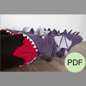 May include: Purple and gray knitted dragon leg warmers with a red mouth and white teeth. The leg warmers are on a person's legs.  ©EmmaBermudezDesigns PDF