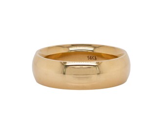 May include: A gold-colored ring with a rounded band. The ring has a smooth, polished surface and a 14K stamp inside the band. The ring is a classic style, suitable for various occasions.