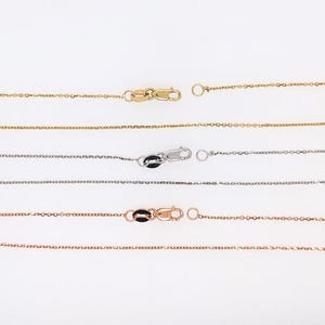 May include: Three gold chains with clasps, one yellow gold, one white gold, and one rose gold.