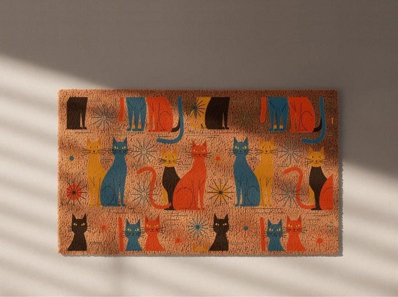 A colorful, patterned door mat with various cat illustrations in different colors and poses.