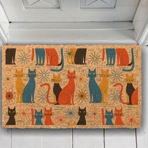 A colorful, patterned door mat with various cat illustrations on it.