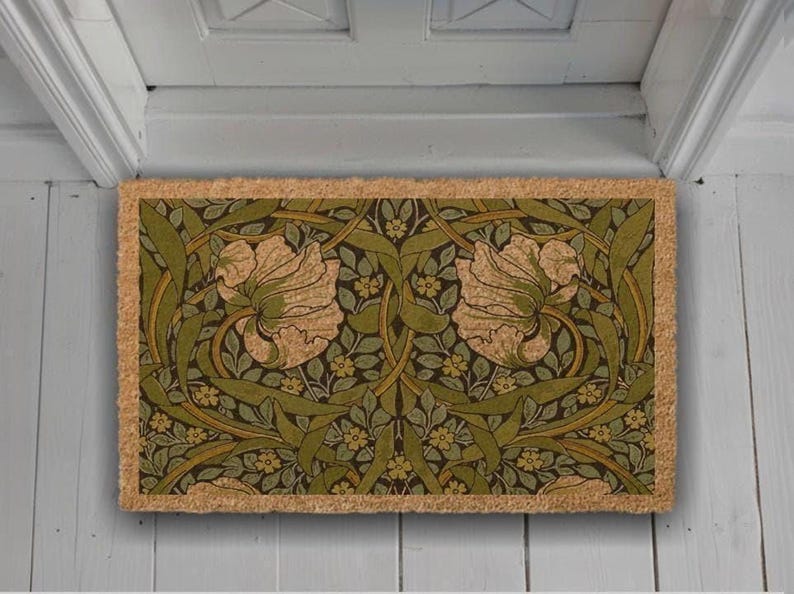 A decorative door mat with a floral pattern in shades of green and brown.