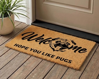 Könnte beinhalten: Rechteckige Fußmatte aus Naturfasern mit dem Wort "Welcome" in Schreibschrift und dem Satz "HOPE YOU LIKE PUGS" in serifenlosen Buchstaben. Eine schwarze Mops-Illustration befindet sich in der Mitte.