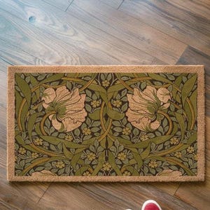 A decorative area rug with a floral pattern on a wooden floor.