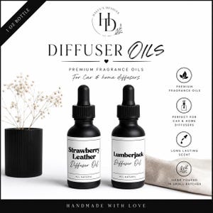 May include: Two 1 oz matte black glass dropper bottles labeled Strawberry Leather and Lumberjack diffuser oils. The bottles feature black dropper caps and white labels. Text includes Haley's Designs, Diffuser Oils, Premium Fragrance Oils, and All Natural.