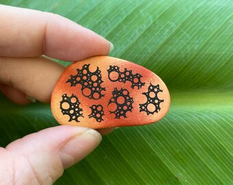 Bubbly orange and black hand painted rock. Acrylic Paint
