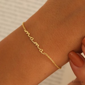 May include: A gold chain bracelet with the word "mama" written in cursive.