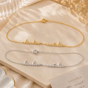 K&ouml;nnte beinhalten: Zwei zarte Kettenarmb&auml;nder, eines in Gold- und eines in Silberoptik, die jeweils die Namen harlow und natalie in Schreibschrift zeigen. Beide Armb&auml;nder verf&uuml;gen &uuml;ber einen runden Federringverschluss und eine verstellbare Verl&auml;ngerungskette.