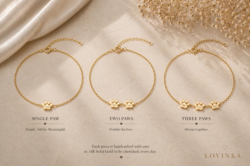 May include: Three gold chain bracelets featuring small paw print charms. The first bracelet has one paw, the second has two, and the third has three. Each charm is engraved with a name. Text labels include SINGLE PAW, TWO PAWS, and THREE PAWS.