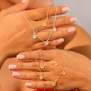 Puede incluir: Dos collares de oro con dijes de huella de pata. Los collares est&aacute;n superpuestos. Las huellas de pata son peque&ntilde;as y delicadas.