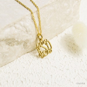 May include: Gold necklace with a delicate chain and a monogram pendant featuring the letters 'S' and 'O' intertwined.