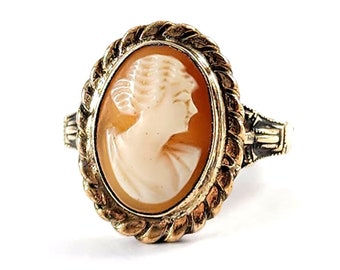 May include: A gold ring with a cameo of a woman's profile set in a rope-like design.
