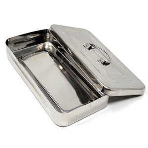 May include: A stainless steel rectangular box with a hinged lid and a handle. The box is open and the lid is resting on the side.
