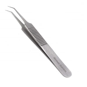 Może przedstawiać: Srebrne pęsety ze skośnym końcem i teksturowanym uchwytem. Pęsety są oznaczone "German Stainless".