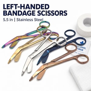 May include: Five 5.5 inch stainless steel left-handed bandage scissors in rainbow, gold, silver, blue, and copper finishes. The text LEFT-HANDED BANDAGE SCISSORS 5.5 in | Stainless Steel is visible at the top, with a white roll of tape and alcohol swab.
