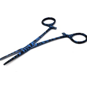 May include: Blue and black zebra patterned hemostats. The hemostats are a medical tool used to clamp blood vessels.