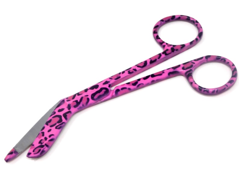 May include: Pink bandage scissors with a leopard print design.