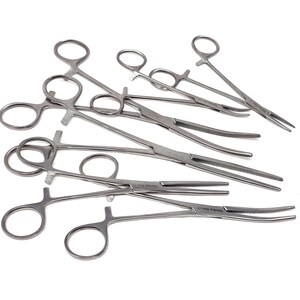 Puede incluir: Una colección de hemostatos quirúrgicos de acero inoxidable de color plateado con mangos de anillo, trinquetes de bloqueo y mandíbulas dentadas. Estos instrumentos médicos incluyen puntas rectas y curvas, todos con un acabado metálico.