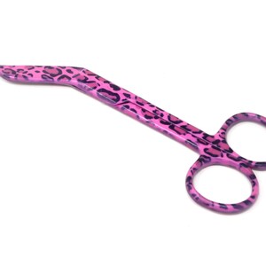 May include: Pink surgical scissors with a leopard print design.