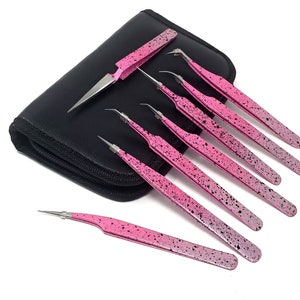 May include: Set of seven pink tweezers with black speckles, in a black zippered pouch. The tweezers have slanted tips and are designed for precision work.