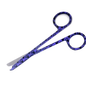 Op de afbeelding: Paarse schaar met een pootprintontwerp. De schaar heeft een scherpe punt en is gemaakt van metaal.