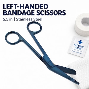 May include: Left-handed bandage scissors made of stainless steel, measuring 5.5 inches in length. The scissors feature a dark blue finish, two finger loops, and a blunt-tipped angled blade. The text "LEFT-HANDED BANDAGE SCISSORS 5.5 in | Stainless Steel" is visible.