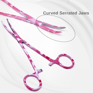 May include: A pair of pink surgical tweezers with a curved serrated jaw design. The tweezers have a white background with a pink floral pattern.