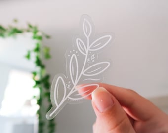 May include: A clear sticker with a white outline of a leafy branch with small white dots and geometric shapes.