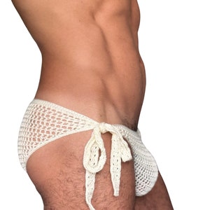 May include: A white crocheted swimsuit with a tie at the side.