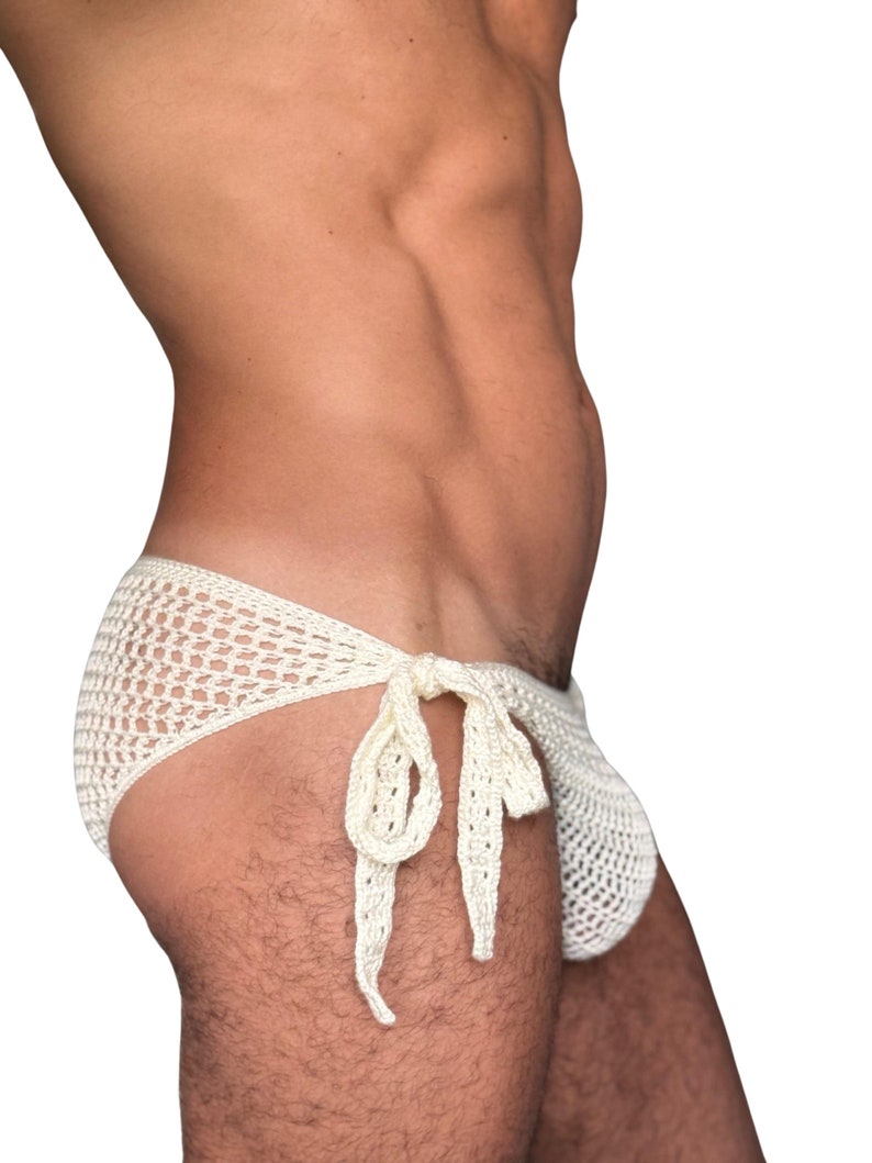 May include: A white crocheted swimsuit with a tie at the side.