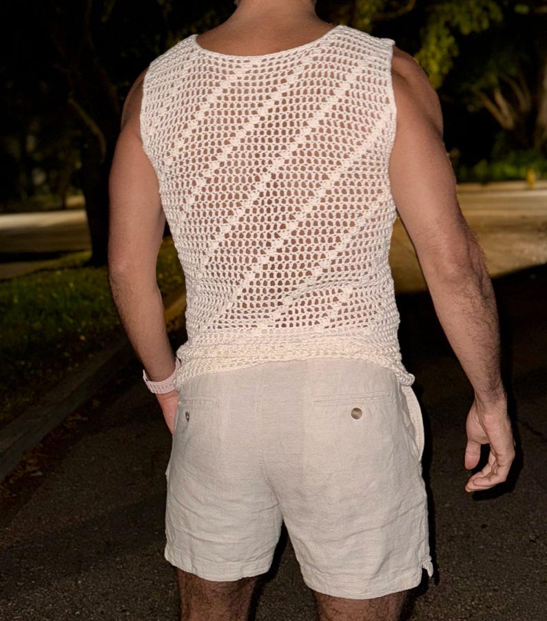 May include: A white crocheted sleeveless top with a diamond pattern and a pair of white linen shorts.