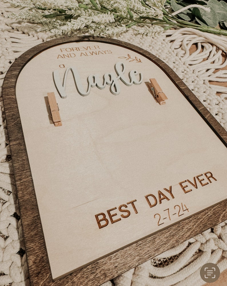 Może przedstawiać: Drewniany znak w kształcie łuku z brązową ramą i białym tłem. Znak głosi "Forever and Always" i "a Nagle" białymi literami. Znak głosi r&oacute;wnież "Best Day Ever 2-7-24" brązowymi literami.
