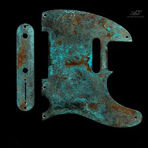 Op de afbeelding: Een set bestaande uit een slagplaat en een controleplaat voor een gitaar, voorzien van een verweerde, geoxideerde koperen afwerking met een textuurpatina in levendige turquoise en diepbruine roesttinten, inclusief voorgeboorde montagegaten.