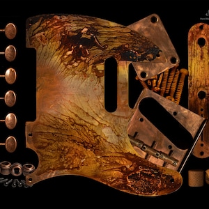 Puede incluir: Un conjunto de piezas de guitarra de cobre, incluyendo un golpeador, clavijas de afinación, puente y tornillos, dispuestos sobre un fondo negro. El golpeador presenta un diseño abstracto único con tonos marrones y amarillos. Incluye el texto "Pick Art Hand Made Custom Pickguards."