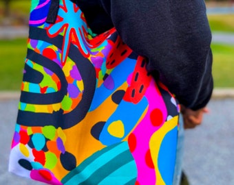 Peut inclure: Un sac fourre-tout coloré avec un motif abstrait noir, blanc et arc-en-ciel. Le sac est fait d'un tissu résistant et a une grande capacité.