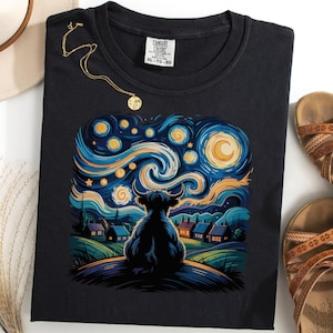 May include: Black t-shirt with a vibrant illustration of a Highland cow observing a starry night sky, in the style of Van Gogh. The design uses swirling blues, yellows, and greens. The shirt is accompanied by sandals and a necklace.