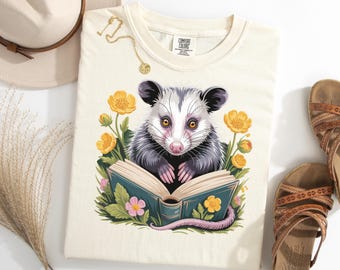 Camiseta de zarigüeya, linda zarigüeya leyendo un libro, popular para amantes de las zarigüeyas, acogedora camiseta de marsupial, regalo de animal literario, top floral con animalito