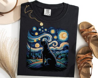 Puede incluir: Camiseta negra con un diseño de perro sobre un cielo nocturno arremolinado al estilo de "La noche estrellada" de Van Gogh. El diseño utiliza azules, amarillos y verdes. También se ven un collar dorado y sandalias marrones.
