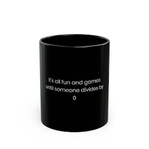 May include: Black ceramic mug with white text that reads "It's all fun and games until someone divides by 0".