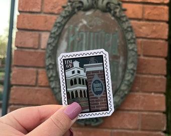 May include: A white sticker with a black border and a picture of the Haunted Mansion. The sticker has the text "HM 69" and "The Haunted Mansion" on it.